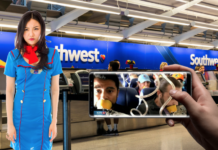 A hand taking a cell phone photo of a Southwest Airlines flight attendant in an airport