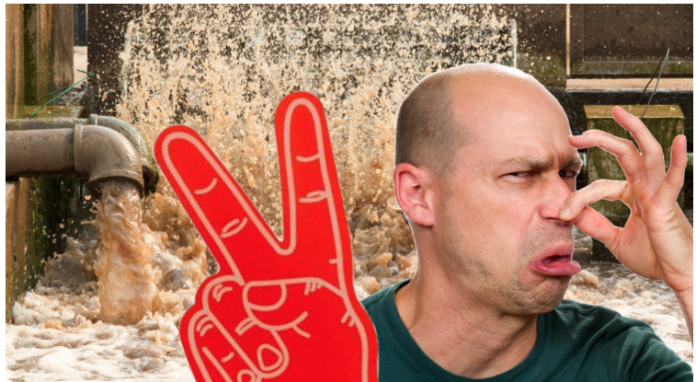 Man holding nose with foam number 2 hand in front of bursting sewage pipes