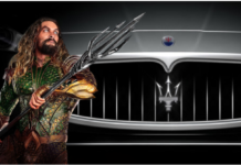 Aquaman with trident in front of gray Maserati grille