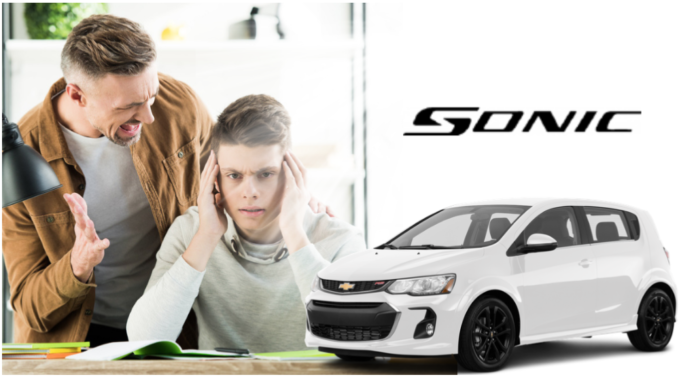 Man lecturing teenage son, white 2019 Chevy Sonic to side