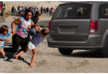 Gray Dodge Caravan at Mexican border fleeing with other migrants