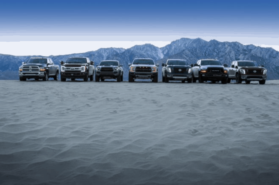A lineup of different brand trucks in a desert