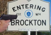 A policer officer's hands holding a pistol are shown in front of an entering Brockton, MA sign.