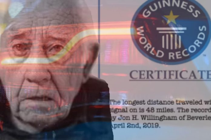 An older man, who has a recommendation for the 2019 GMC Acadia vs 2019 Chevy Traverse, is shown next to his Guinness World Record certificate.