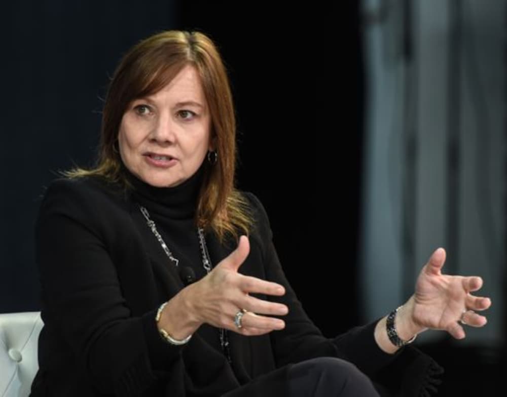 Mary Barra is is speaking with her hands out in front of her.