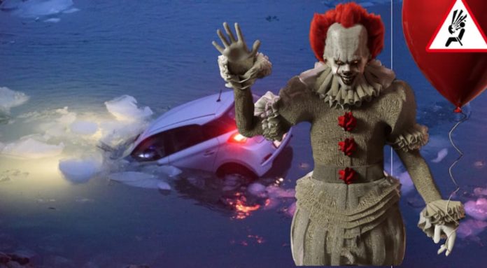 Pennywise is waving while a car sinks into a frozen lake.