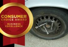 A car with a donut rim covered in wrenches has an award shown for Consumer Choice for Business Excellence.