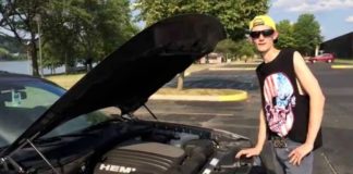 A teen boy in a skull cut-off is standing next to his car after leaving a Dodge dealership.