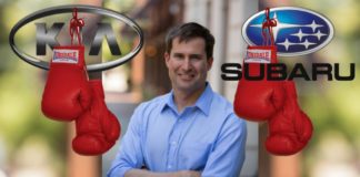 The Kia and Subaru logos have boxing gloves hanging off of them, while Congressman Seth Moulton is in the middle smiling.