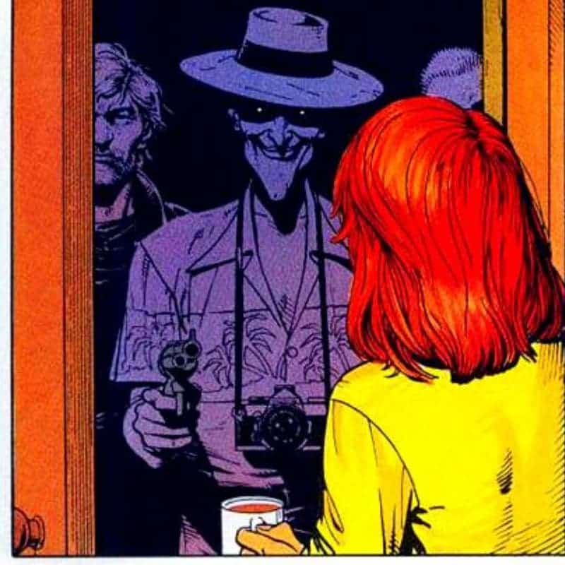 The comic book Joker is pointing a gun at a redhead.