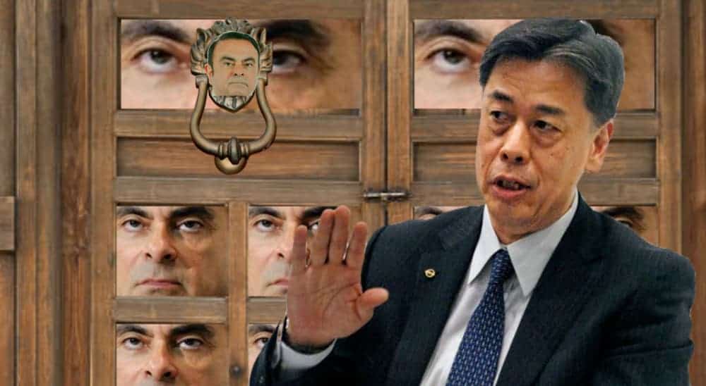 The Nissan CEO is in front of a door with the face of the ghost of the former CEO all over it.