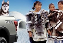 Inuit people are standing next to a Ford Pro4x truck with a husky in the back, debating the 2020 Ford F-150 vs 2020 Nissan Titan.