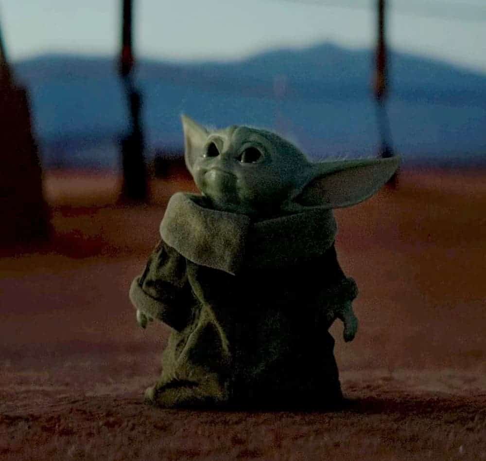 Baby Yoda is wearing his robe and looking up.