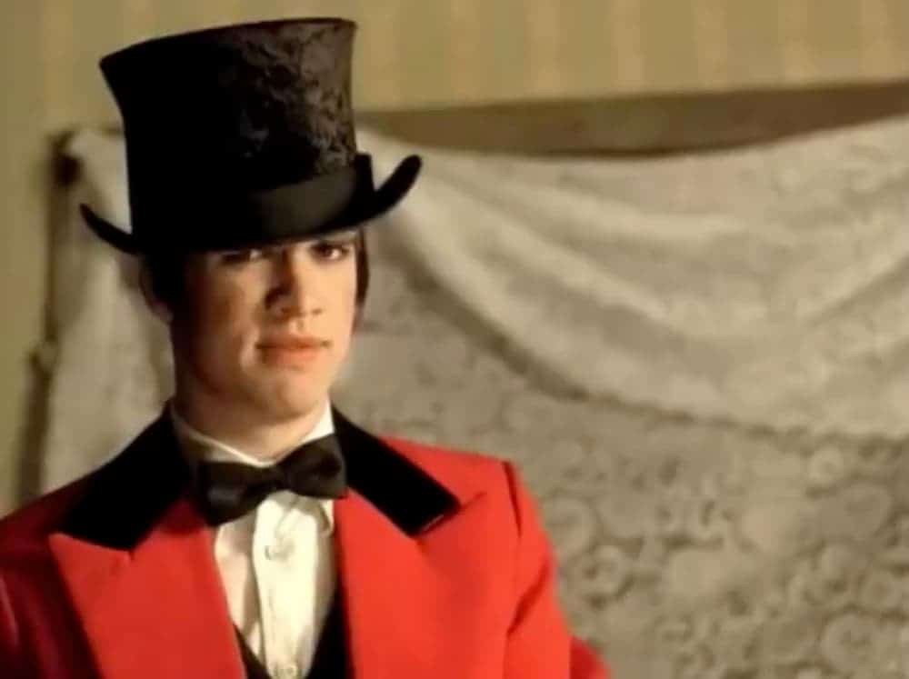The singer of Panic at the Disco is in a red coat and black top hat.