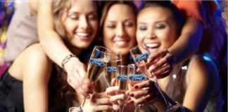 A group of women at a party with champagne glass with the Ford logo on them