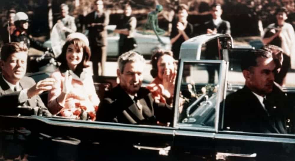 The Kennedy's are in the motorcade before the assassination with an alien behind them.