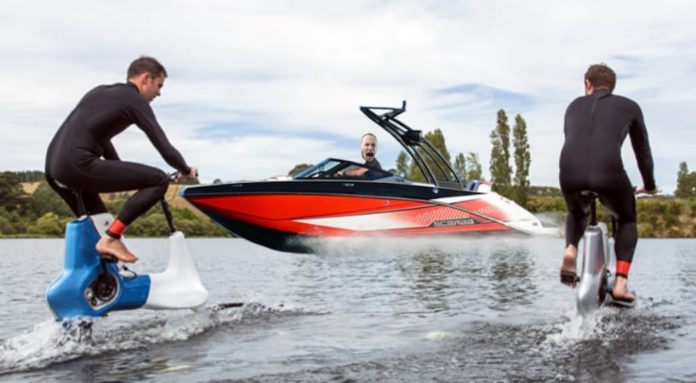 E-water bikes are riding towards an angry man in a boat, which may be an issue in live auto news.