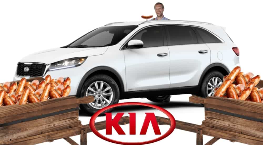 A German man is behind a white 2020 Kia Sorento with wheelbarrows full of sausages in front.