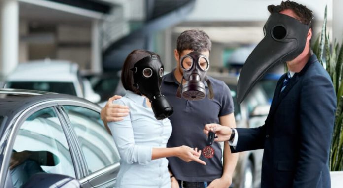 A couple is taking keys from a car salesman while they all wear face masks to prevent the virus, which is in an issue in live auto news.