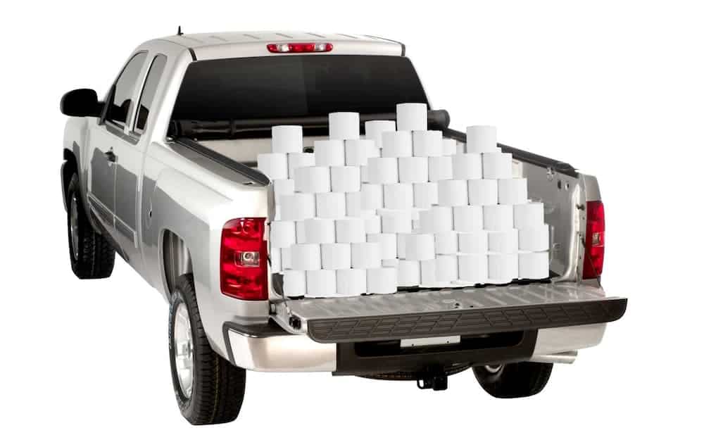 A silver truck is on a white background with the bed loaded with toilet paper.