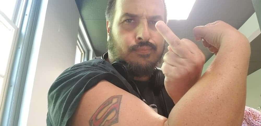 A Lemon employee is flipping off the camera with an exposed Superman arm tattoo.