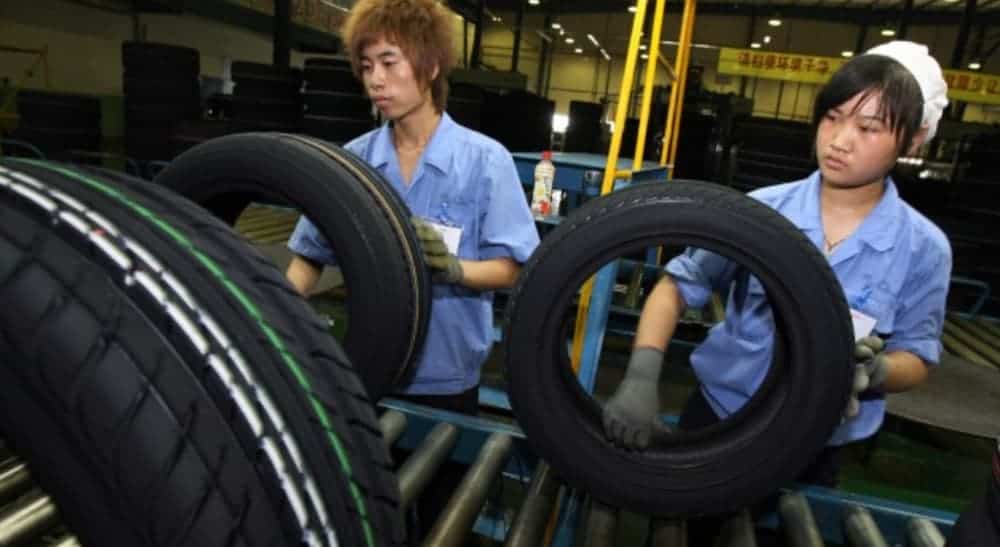 Workers in a factory are checking tires before sending them to tire shops.
