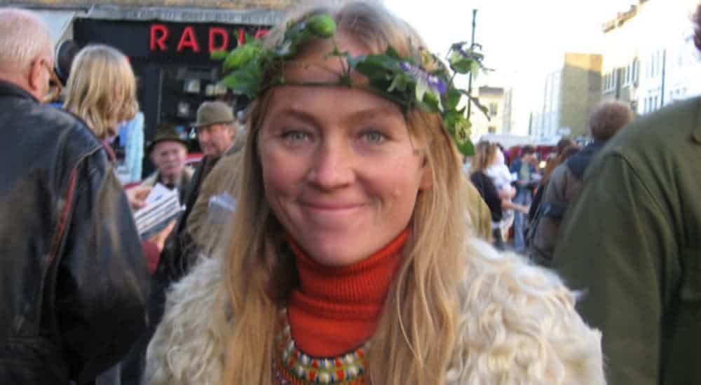 A woman with blonde hair is shown with a floral headdress on.