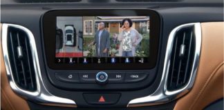A closeup shows a State Farm commercial playing on the infotainment screen of a 2020 Chevy Equinox.