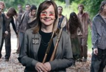 Mary Barra, the head of GM, is wearing war paint, holding spears and has a patch that reads 'badass mother' while standing in front of zombies.