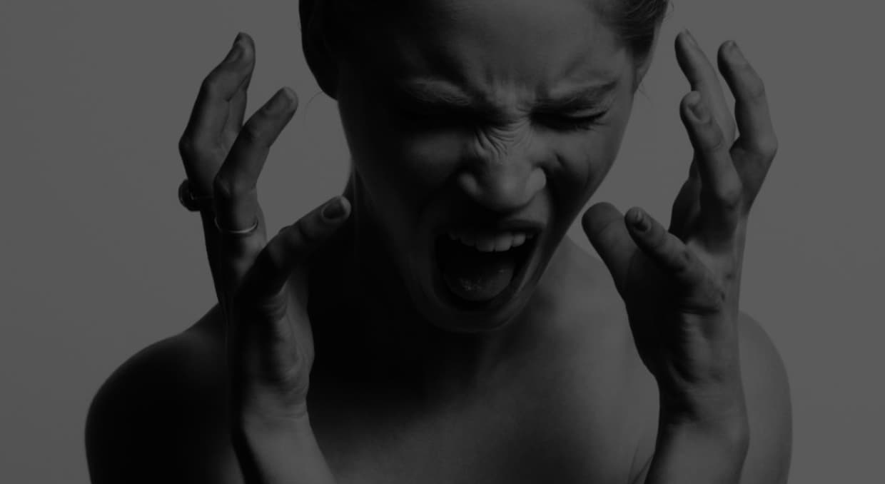 A dark grey color is laid over a woman screaming.