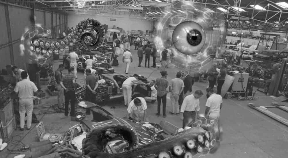 A black and white photo is showing a production floor full of people with a floating eye and squid tentacle at Ford dealership near you.