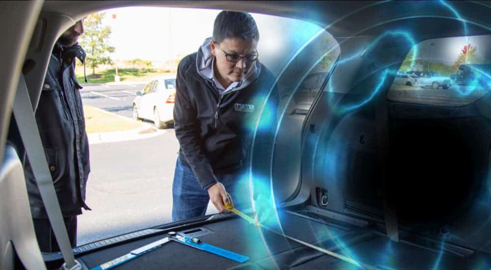 The trunk of a 2021 Kia Sorento is being opened with a black hole inside it.