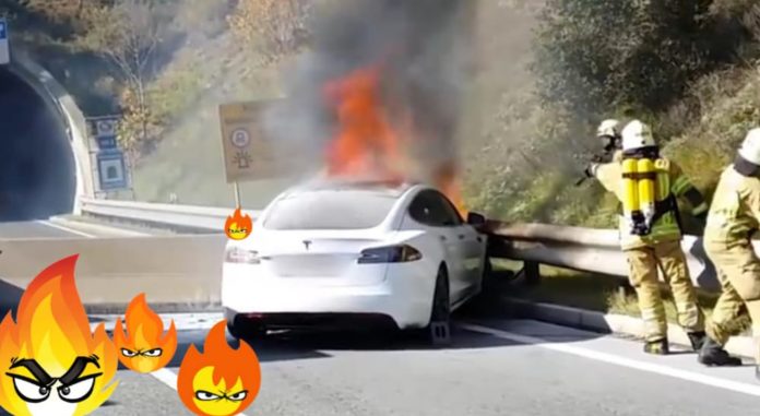 A Tesla has a car fire that is being put out by firefighters on the highway.