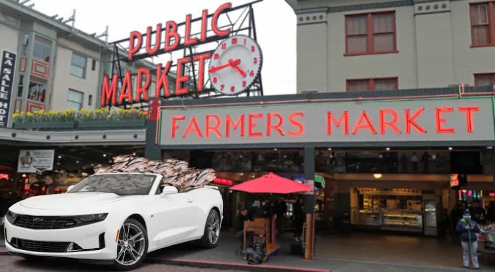 A white 2021 Chevy Camaro is parked at a fish market after winning the 2021 Chevy Camaro vs 2021 Ford Mustang comparison.