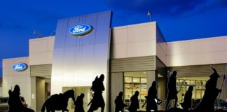 The silhouettes of the Fellowship of the Ring characters are in front of a Ford dealership.