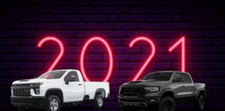 A side-by-side is shown of a white Silverado and a black Ram against a brick wall and neon 2021 sign after the 2021 Silverado diesel vs 2021 Ram 1500 diesel comparison.