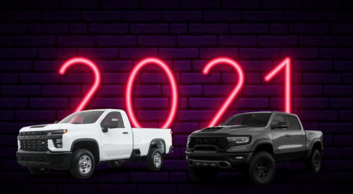 A side-by-side is shown of a white Silverado and a black Ram against a brick wall and neon 2021 sign after the 2021 Silverado diesel vs 2021 Ram 1500 diesel comparison.