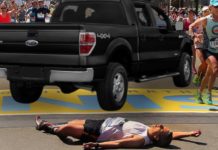 A marathon runner is laying on the ground in front of a black Ford F-150 that left a Ford dealers in Cincinnati.