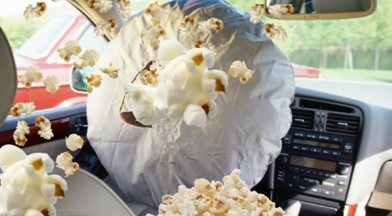 A close up shows a air bag deploying full of popcorn.