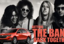 A red 2021 Chevy Equinox is shown parked in front of a black and white band photo after winning the 2021 Chevy Equinox vs 2021 Ford Escape comparison.