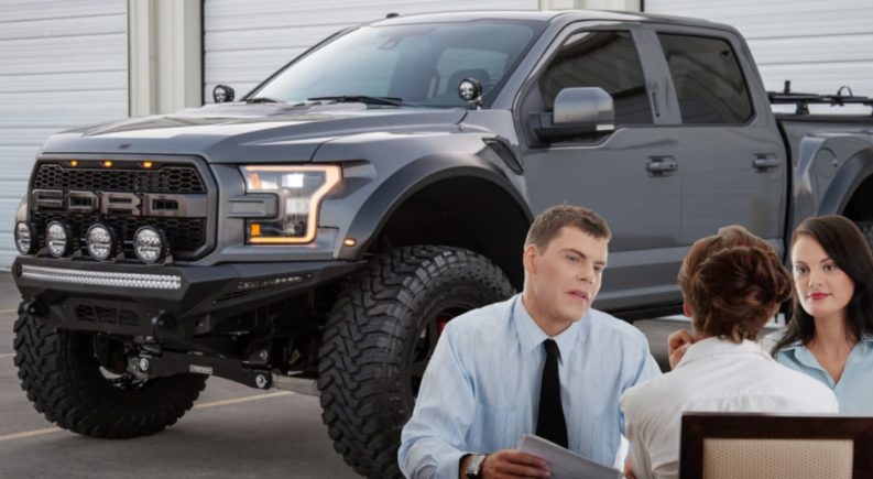 An interview is taking place in front of a dary gray 2021 Ford F-150 Raptor.