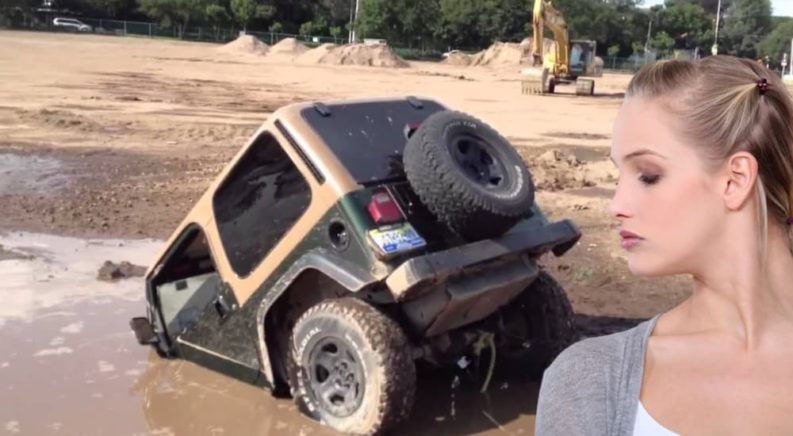 A green and tan Jeep Wrangler, the predecessor to the 2021 Jeep Wrangler 4xe, is shown sinking in the mud.