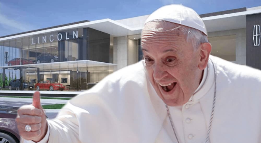 The Pope is giving a thumbs up in front of a Lincoln Dealership.