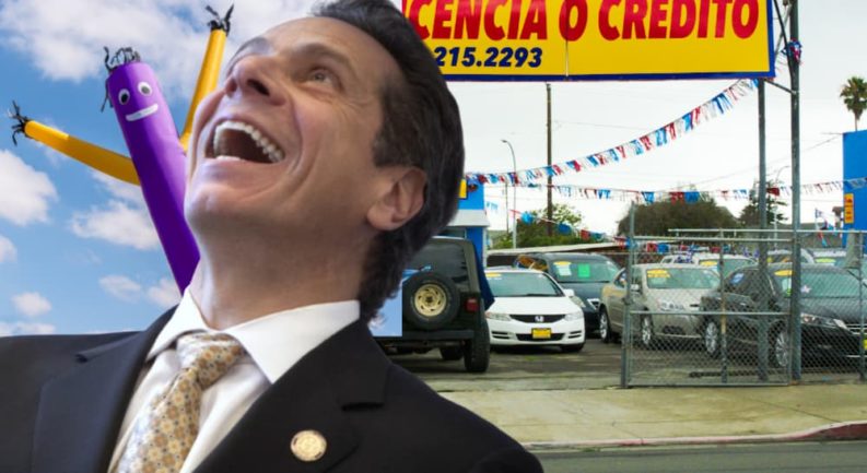 Andrew Cuomo is laughing in front of a NY Certified Pre-Owned Ford dealer.