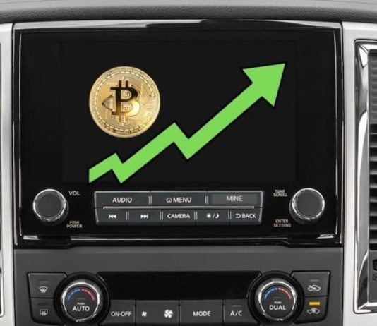 An infotainment screen shows bitcoin prices on the rise during a 2021 GMC Sierra 1500 vs 2021 Nissan Titan comparison.