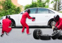 A white car is shown the with wheels being removed by a pit crew after leaving one of the most popular Cincinnati tire shops.