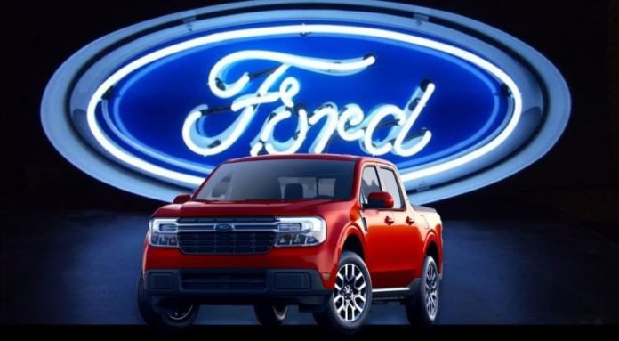 A red 2022 Ford Maverick is shown in front of a neon light Ford sign at a Ford Maverick dealer.
