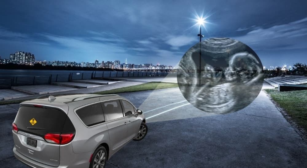 A silver used Chrysler Pacifica is shown beaming an ultrasound from the headlights.