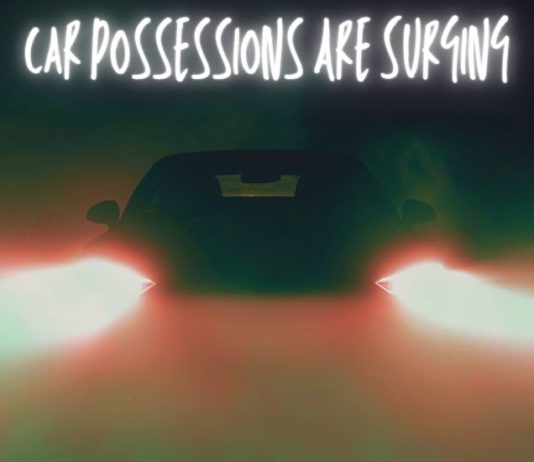 A car is shown from the front in darkness.