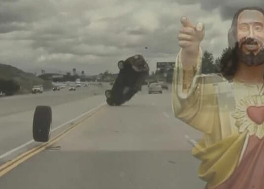 Jesus is shown giving thumbs up to an automobile accident during live auto news.